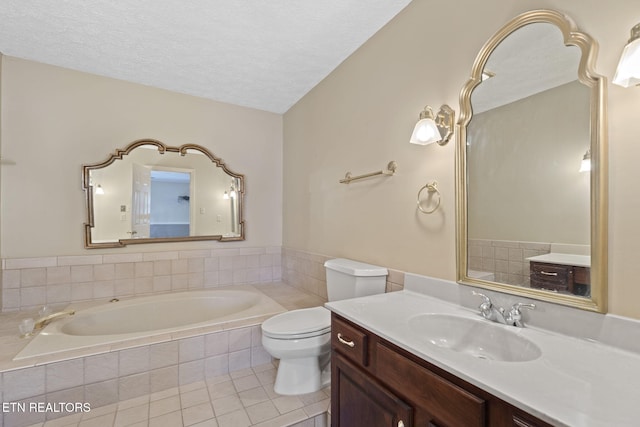 bathroom featuring tile patterned floors, toilet, a textured ceiling, vanity, and a relaxing tiled tub