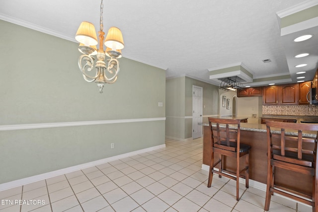 kitchen with crown molding, pendant lighting, backsplash, and a chandelier