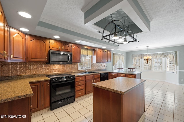 kitchen featuring a tray ceiling, black appliances, decorative light fixtures, kitchen peninsula, and a chandelier