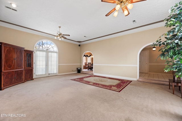 interior space with ceiling fan, ornamental molding, and light carpet