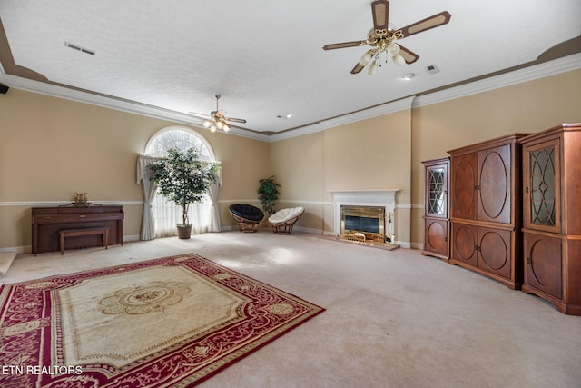 carpeted living room with ceiling fan and ornamental molding