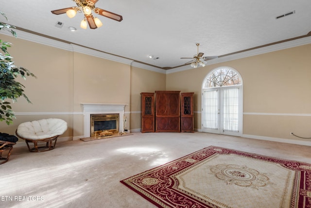 carpeted living room featuring ornamental molding and ceiling fan