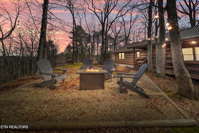 yard at dusk featuring an outdoor fire pit