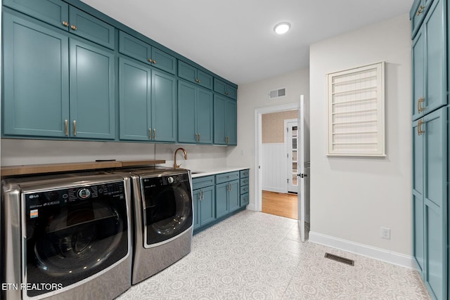 clothes washing area with sink, cabinets, and washing machine and clothes dryer