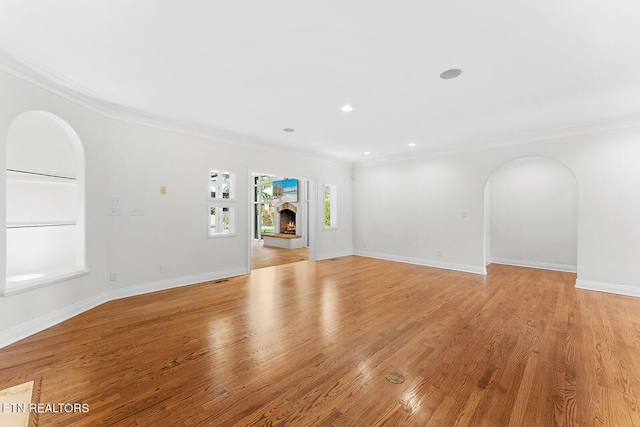 unfurnished living room with crown molding and light hardwood / wood-style floors