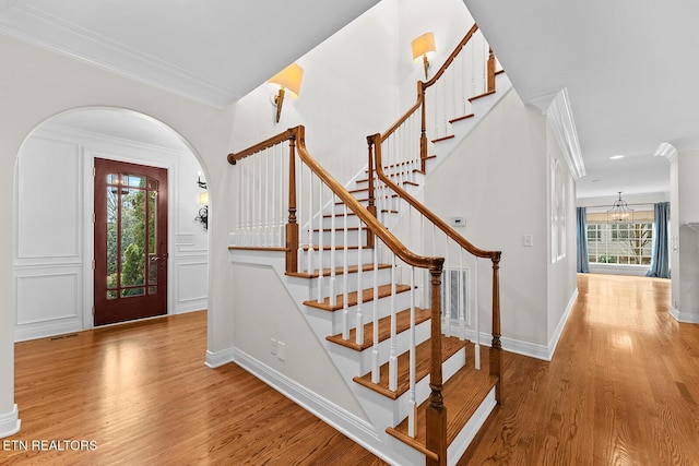 entryway featuring crown molding, hardwood / wood-style floors, and an inviting chandelier