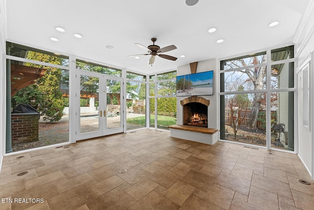 unfurnished sunroom with ceiling fan