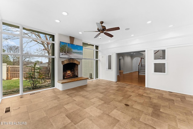 unfurnished living room featuring floor to ceiling windows and ceiling fan