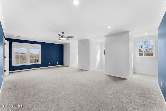 unfurnished room featuring ornamental molding, a wealth of natural light, light carpet, and ceiling fan