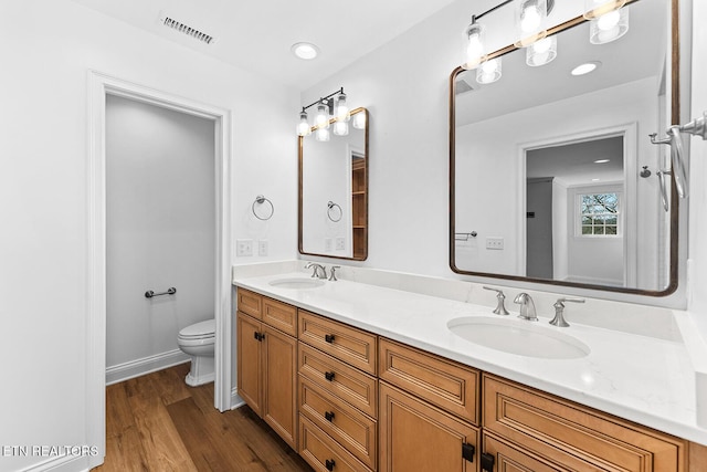 bathroom featuring wood-type flooring, vanity, and toilet