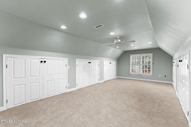 additional living space featuring vaulted ceiling, light colored carpet, and ceiling fan