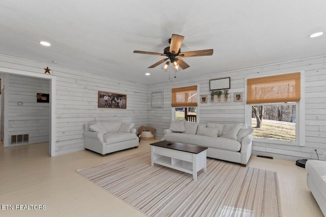 living room featuring plenty of natural light, light wood-type flooring, and ceiling fan