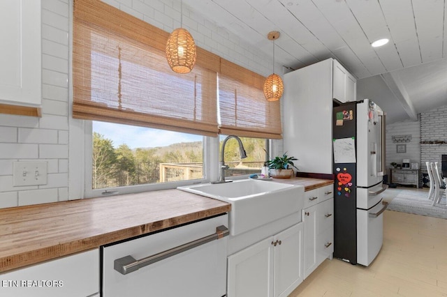 kitchen featuring sink, white cabinetry, decorative light fixtures, high quality fridge, and dishwasher