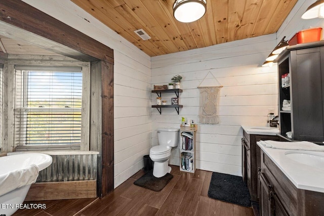 bathroom featuring hardwood / wood-style flooring, vanity, wooden ceiling, a tub, and toilet