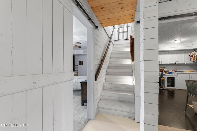 stairs featuring wooden ceiling and wooden walls