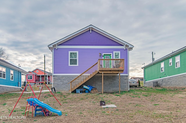 rear view of property with a playground and central AC