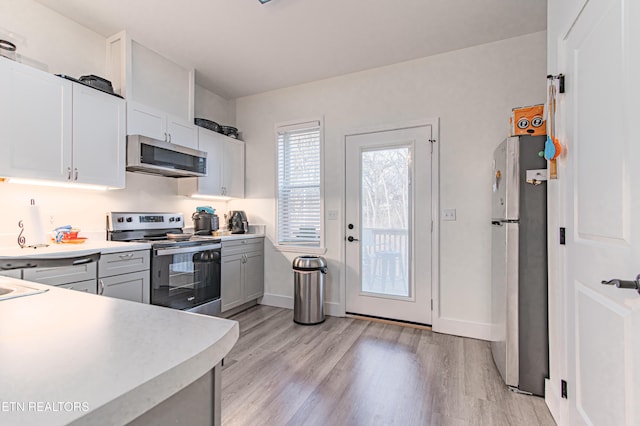 kitchen with gray cabinets, light hardwood / wood-style floors, white cabinets, and appliances with stainless steel finishes