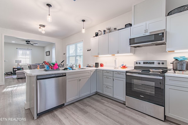 kitchen featuring sink, appliances with stainless steel finishes, gray cabinetry, decorative light fixtures, and kitchen peninsula