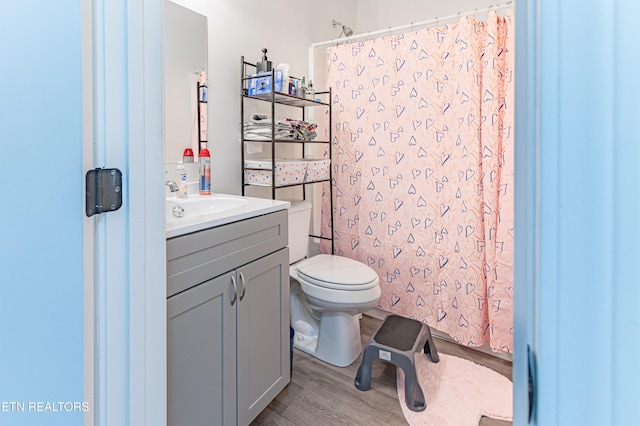 bathroom with vanity, toilet, and hardwood / wood-style floors