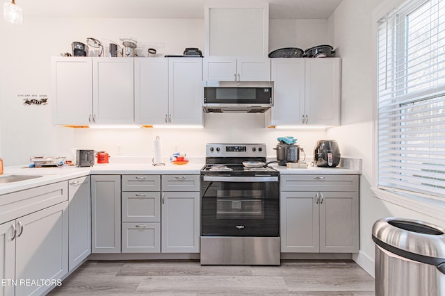 kitchen with white cabinets, stainless steel appliances, and light wood-type flooring