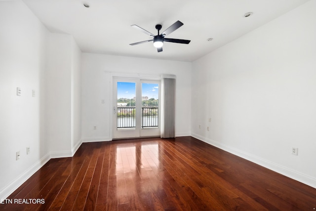 empty room with dark hardwood / wood-style floors and ceiling fan