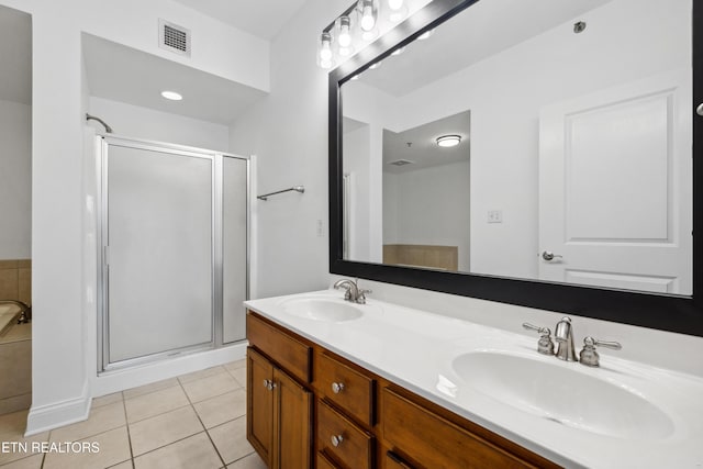 bathroom with tile patterned flooring, vanity, and a shower with door