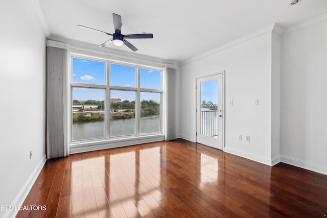 empty room featuring ornamental molding, a water view, ceiling fan, and dark hardwood / wood-style flooring