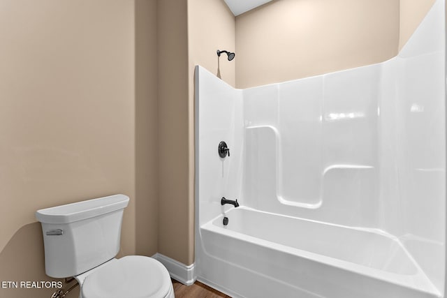 bathroom with hardwood / wood-style flooring, toilet, and shower / bath combination