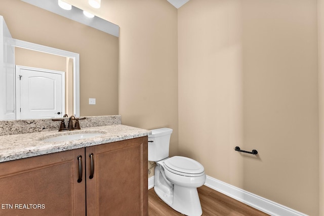 bathroom with vanity, hardwood / wood-style flooring, and toilet