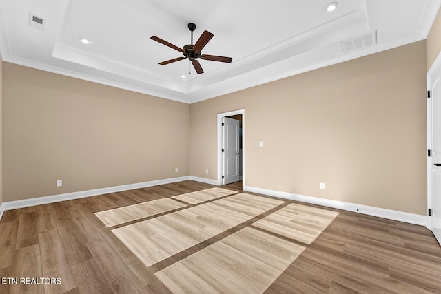 interior space with crown molding, hardwood / wood-style floors, ceiling fan, and a tray ceiling