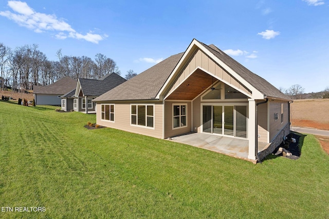 rear view of property featuring a yard, ceiling fan, and a patio area