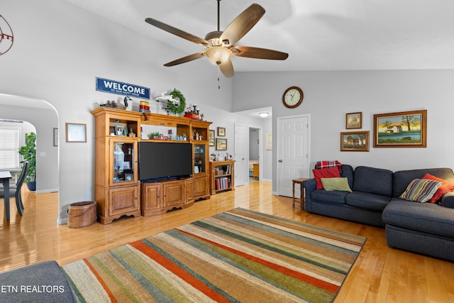 living room with wood-type flooring, ceiling fan, and high vaulted ceiling