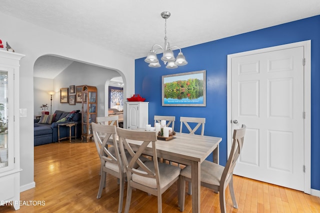 dining area featuring an inviting chandelier and light wood-type flooring