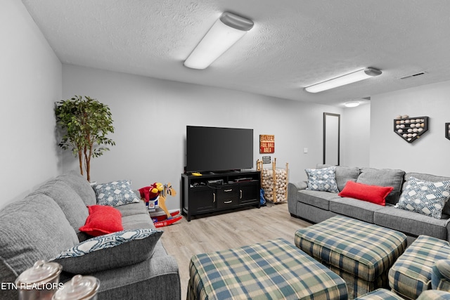 living room with a textured ceiling and light wood-type flooring