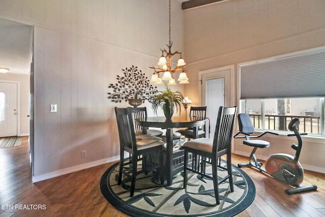 dining area with wood-type flooring and a chandelier