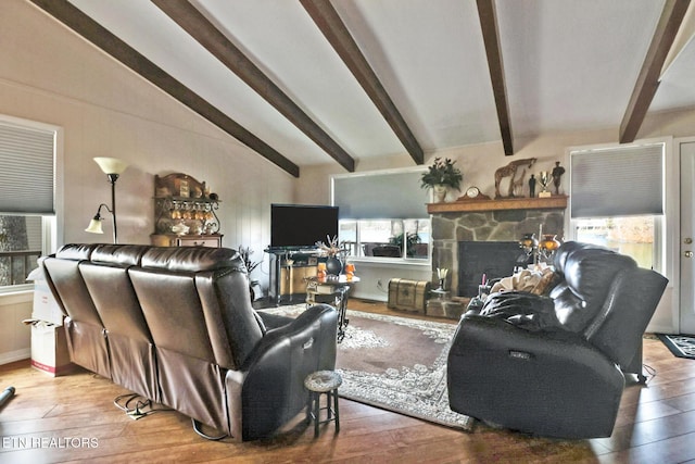 living room featuring hardwood / wood-style floors, a fireplace, and vaulted ceiling with beams