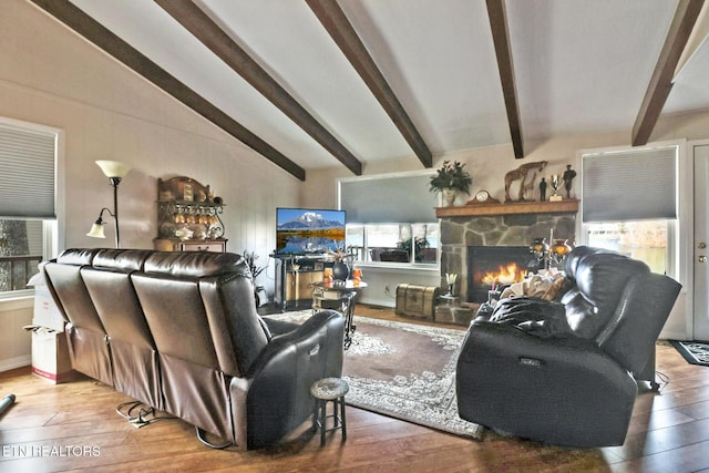 living room with hardwood / wood-style flooring, a fireplace, and vaulted ceiling with beams