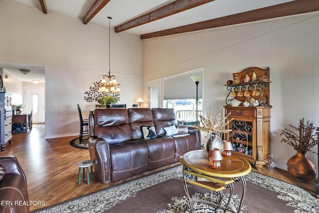 living room with hardwood / wood-style flooring, vaulted ceiling with beams, and a chandelier