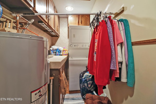 spacious closet with water heater and stacked washer and dryer