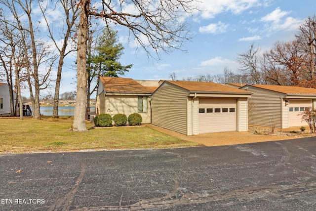 view of front facade featuring a water view, a garage, and a front yard