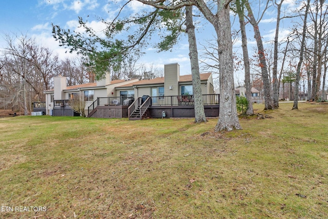 back of house with a wooden deck and a yard