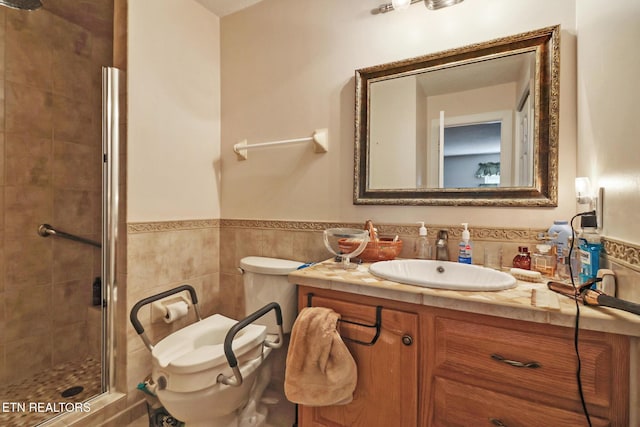 bathroom featuring tile walls, vanity, a shower with shower door, and toilet