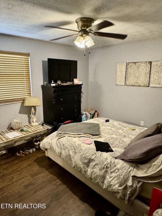 bedroom featuring a textured ceiling, ceiling fan, and wood finished floors