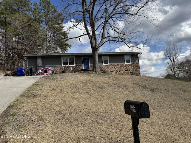 ranch-style house featuring stone siding