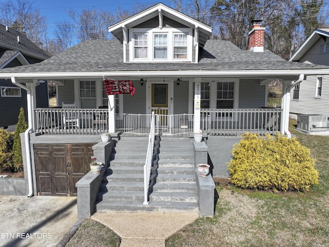 view of front of property with a garage, central AC, and a porch