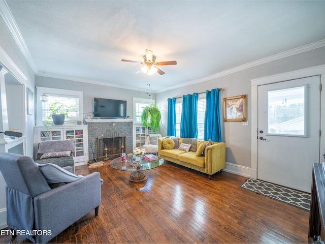 living room featuring hardwood / wood-style flooring, ornamental molding, a brick fireplace, and ceiling fan