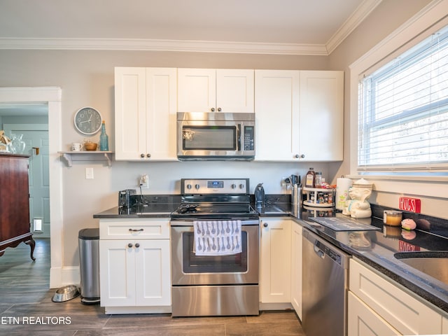 kitchen featuring stainless steel appliances, ornamental molding, and white cabinets