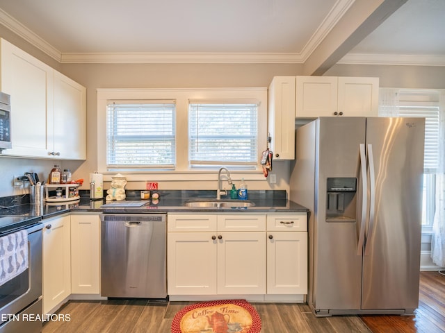 kitchen with hardwood / wood-style flooring, appliances with stainless steel finishes, sink, and white cabinets