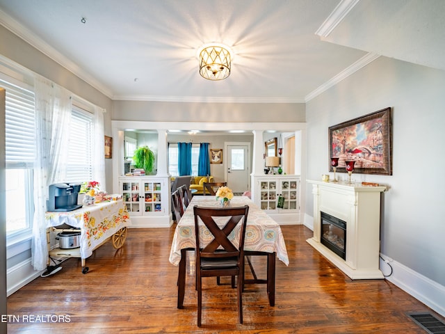 dining space featuring decorative columns, crown molding, and dark hardwood / wood-style floors