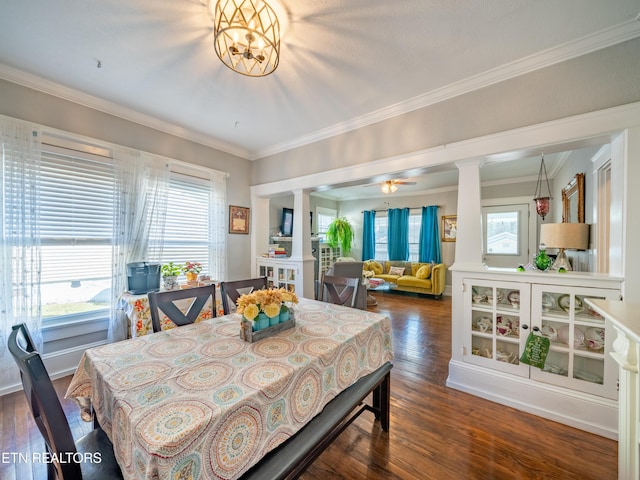 dining room featuring decorative columns, crown molding, ceiling fan, and dark hardwood / wood-style flooring